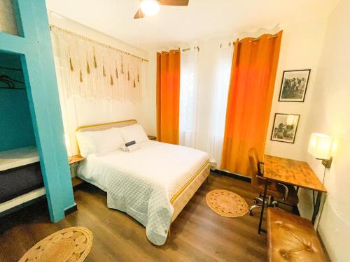 圣地亚哥ITH Mission Beach Backpacker Hostel的一间卧室配有床和橙色窗帘