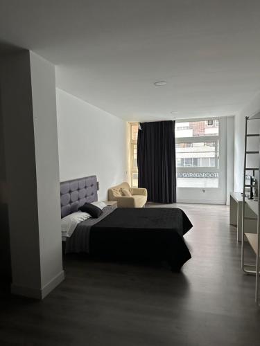 毕尔巴鄂Apartamentos RK 13的卧室配有床、椅子和窗户。