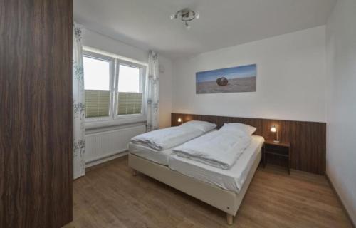 库克斯港Op de Geest 10的一间卧室设有一张床和一个窗口