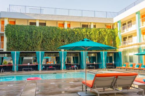 凤凰城The Clarendon Hotel and Spa的酒店旁的游泳池配有椅子和遮阳伞