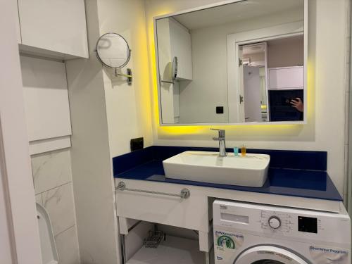 巴统Sea View Panoramic Suite Orbi City的一间带水槽和镜子的浴室以及一台洗衣机