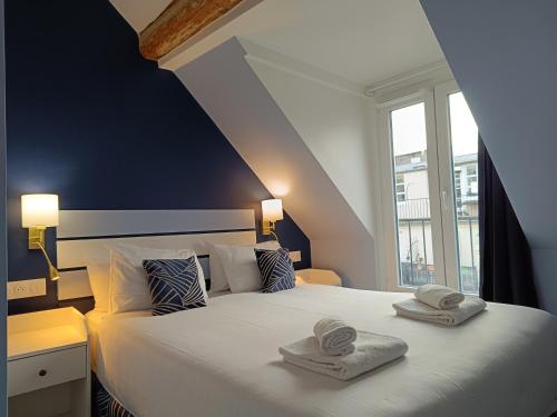 巴黎Hôtel Apollo Opéra的一间卧室配有一张大床和毛巾