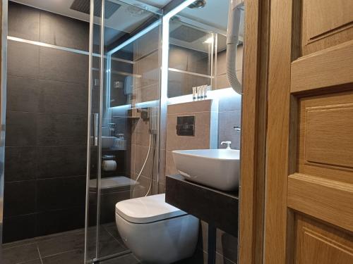 巴黎Hôtel Apollo Opéra的浴室配有卫生间、盥洗盆和淋浴。