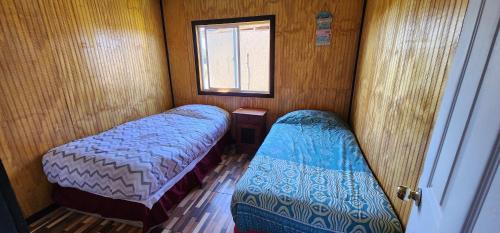 达卡卫Cabaña buck的小房间设有两张床和窗户