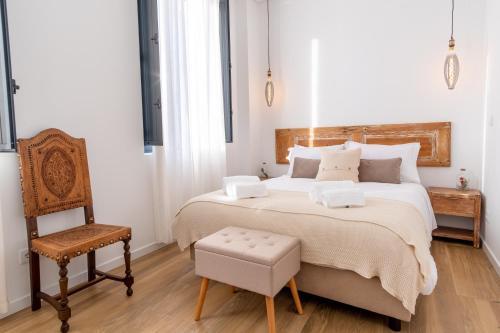 科维良Apartamentos do Mercado的一间卧室配有一张大床和一把椅子