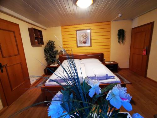 洛弗附近魏斯巴赫Gasthof Geronimo的一间设有蓝色鲜花的床的房间