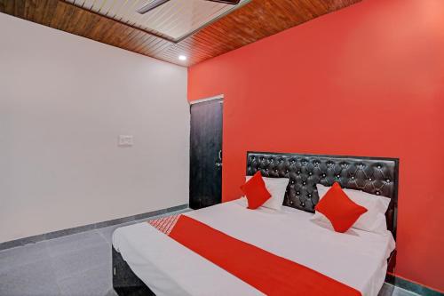 坎普尔The Cawnpore Inn的卧室设有红色的墙壁和一张床