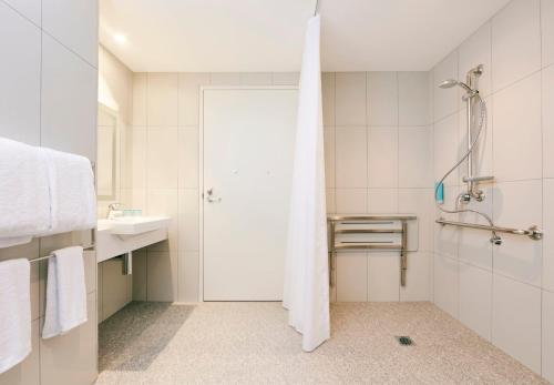 悉尼智选假日酒店，悉尼麦格理公园的带淋浴和盥洗盆的白色浴室