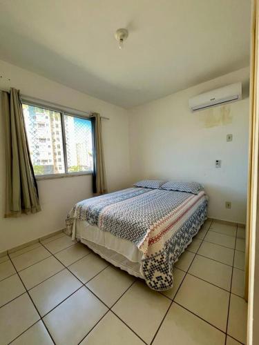 阿拉卡茹Apartamento Clube 3/4 com Ar-condicionado的卧室位于客房的角落,配有一张床