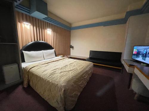 桃园市溫情自助旅店的配有一张床和一台平面电视的酒店客房
