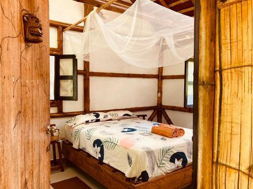 莫姆皮切La Caleta的一间卧室配有一张带天蓬的床