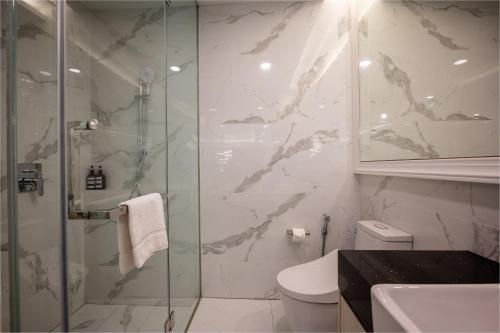 吉隆坡Societe Hartamas by Lyfehaus的一间带玻璃淋浴和卫生间的浴室
