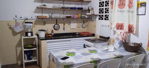 乌巴图巴Casa prática e completa próxima de tudo的一间带桌子和炉灶的小厨房