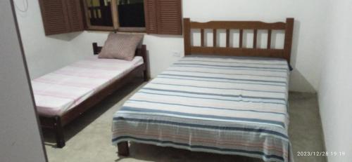 乌巴图巴Casa prática e completa próxima de tudo的一间卧室设有两张床和窗户。