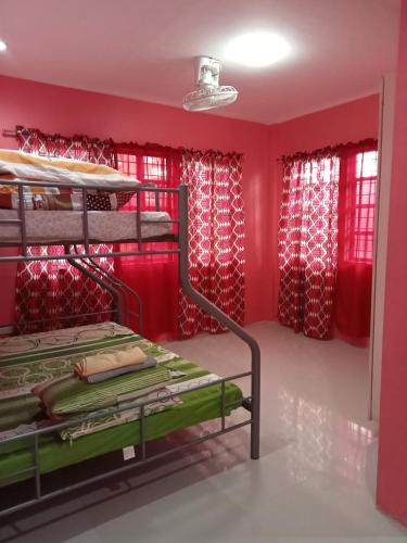 董索Josephine's Home Donsol Sorsogon的客房设有双层床和红色窗帘。