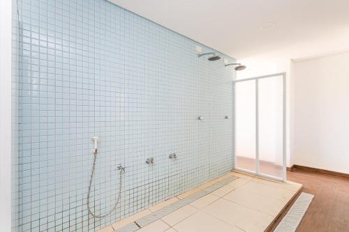 弗洛里亚诺波利斯Predio nos Ingleses pe-na-areia com piscina - Aquarelle的带淋浴的浴室和蓝色瓷砖墙壁