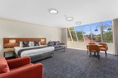 阿德莱德Comfort Hotel Adelaide Meridien的酒店客房带一张床、一张桌子和椅子