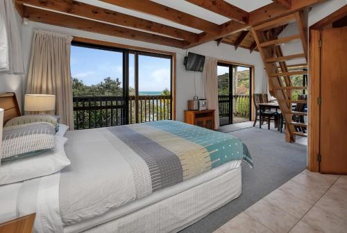 Cable BayMacrocarpa Cottage - Cable Bay Holiday Home的一间卧室设有一张床和一个阳台