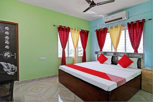 加尔各答The Blue Pearl Hotel的一间卧室配有红色和黄色窗帘的床
