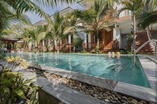 富国Valentina Resort & Spa Phu Quoc的一座棕榈树游泳池和一座房子