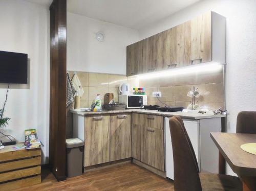 弗尔尼亚奇卡矿泉镇Petrović Apartman的一个带木制橱柜和桌子的小厨房