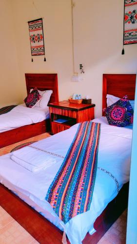 琅勃拉邦天堂鸟花园客栈的配有2张床位的带2个床头柜的房间