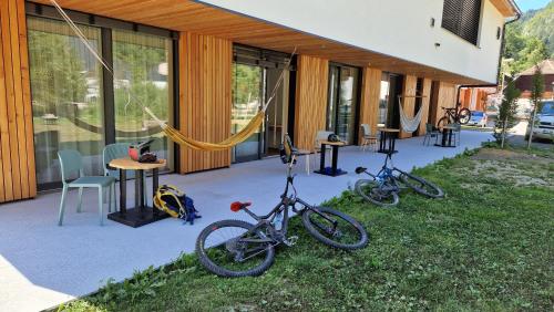 Črna na KoroškemGuesthouse Na trati的两辆自行车停在大楼外的草上