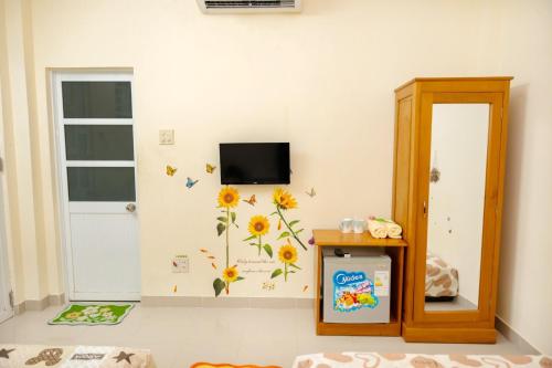 芽庄Lucky Home的一间墙上有向日葵的房间