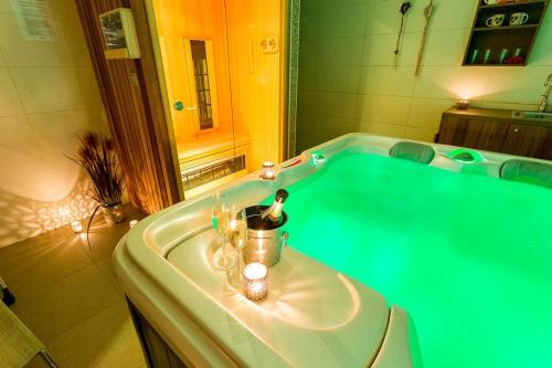 拉什科埃纳别墅酒店的一间带绿色浴缸和蜡烛的浴室