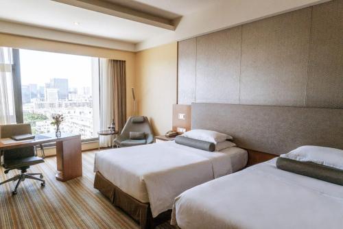 厦门厦门君泰酒店的酒店客房配有两张床和一张书桌