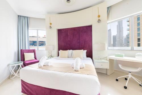 迪拜Downtown Luxury - 5 star Hotel Facilities - 5 min walk to Dubai Mall的一间卧室配有一张大床和一张书桌