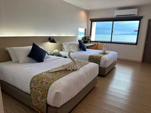 Pearl Andaman Resort Ranong Koh Koo的酒店客房设有两张床和大窗户。