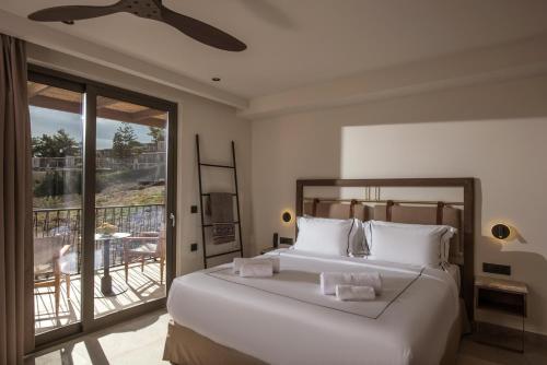 伊罗达Elounda Infinity Exclusive Resort & Spa - Adults Only的一间带一张白色大床的卧室和一个阳台