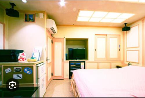 Ayabe綾部アイネ的一间卧室配有一张床,并在一间客房内配有电视。