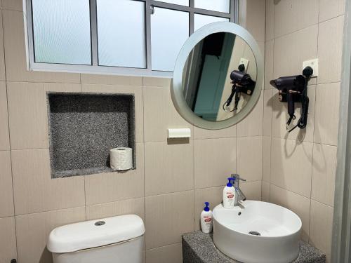 金宝Home Feel-Camellia Suites的一间带卫生间、水槽和镜子的浴室