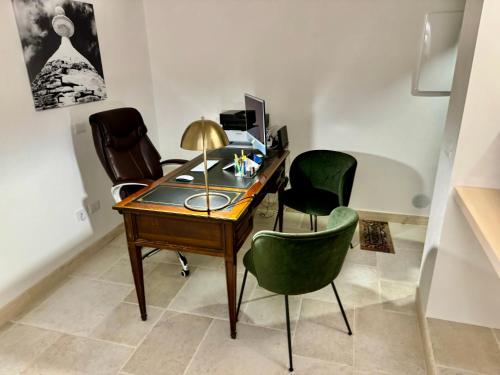 阿尔贝罗贝洛Trulli Contento - Rooms & Apartments的一张桌子,上面有三把椅子和一台电脑