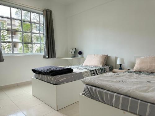 金宝Home Feel-Camellia Suites的带窗户的客房内设有两张单人床。