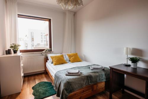 克拉科夫2-bedroom Apartment with garage in the city center的一间卧室配有一张带黄色枕头的床和一扇窗户