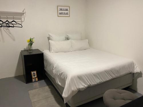 SandtonPeaceful Suburban Utopia的一间卧室配有一张带白色床单和一张桌子的床。