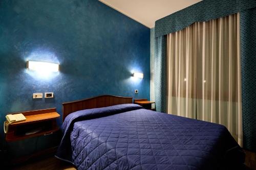 AltedoHOTEL PARADISO的一间卧室配有紫色的床和蓝色的墙壁