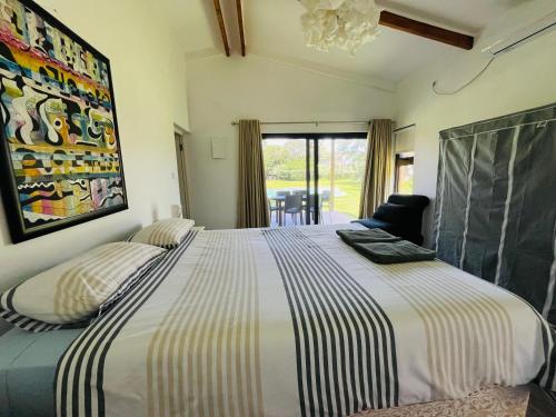 蓬塔杜欧鲁Twin House #2的一间卧室配有一张带条纹床单的大床