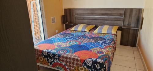 圣保罗Vacances paisibles的一间卧室配有一张带五颜六色棉被的床