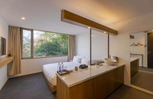 杭州杭州云树酒店的一间卧室配有床和水槽,还有一间浴室