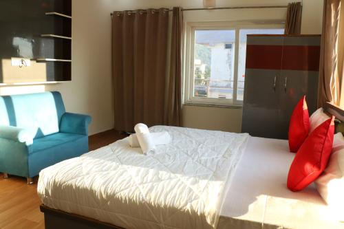 瑞诗凯诗Yoga Vairagyam Tapovan的一间卧室配有一张带蓝色椅子的床和窗户