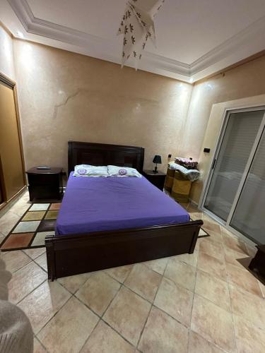 杰迪代Holikeys - El jadida - 2 Ch - Sidi Bouzid 001的一间卧室配有一张带紫色毯子的床