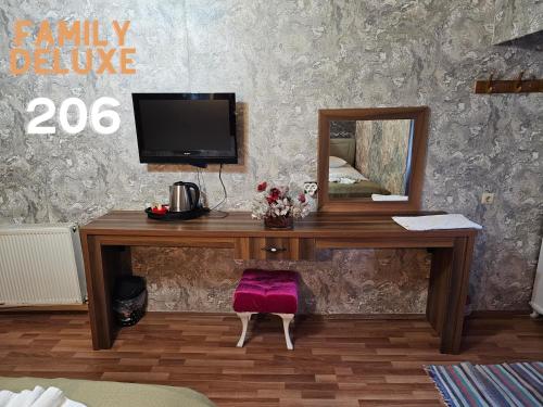内夫谢希尔Glorious House Goreme的一张木桌、一台电视和镜子
