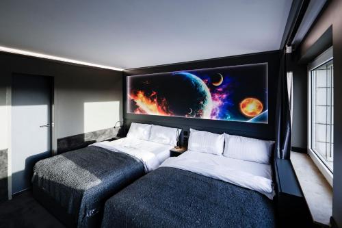 汉堡Sleephotels Cosmos的一间卧室设有两张床,墙上配有电视。