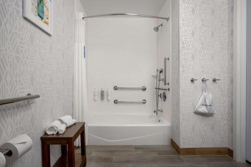 曼西曼西汉普顿酒店及套房的白色的浴室设有浴缸和水槽。