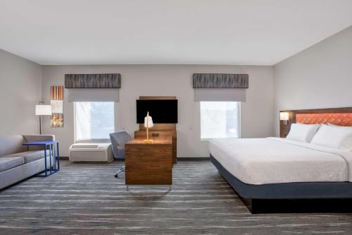 曼西曼西汉普顿酒店及套房的酒店客房,配有床和沙发
