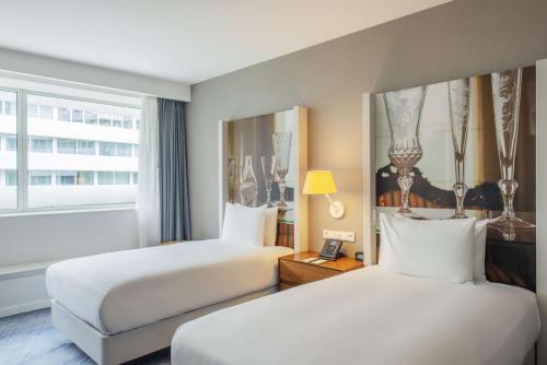 弗罗茨瓦夫弗罗茨瓦夫希尔顿逸林酒店的酒店客房设有两张床和窗户。